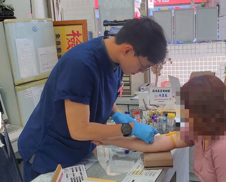 Seorang teknolog medis sedang mengambil darah di Chang An Medical Laboratory